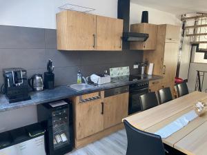 a kitchen with wooden cabinets and a table with chairs at Mosel Röschen in Bernkastel-Kues