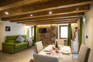 un soggiorno con tavolo e divano verde di Esprit Carrel a Valtournenche