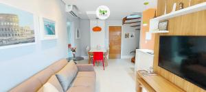 a living room with a couch and a large flat screen tv at COSTE0100 - Residencial Luz das Acácias in Salvador
