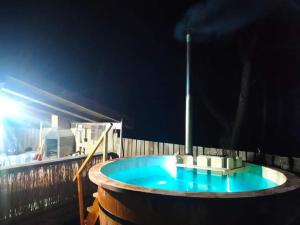 a large wooden tub with a blue water at Pensiunea Narcisa cu Ciubar in Mălăeşti
