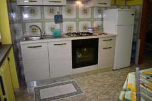 a kitchen with a refrigerator and a stove and a sink at La casa di Antonio in Briatico