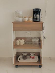 un estante con tazas y otros artículos de cocina. en Buritaca House en Buritaca