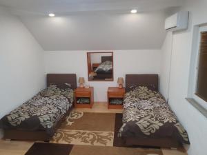 1 dormitorio con 2 camas y espejo en House Apartment Azra en Sarajevo