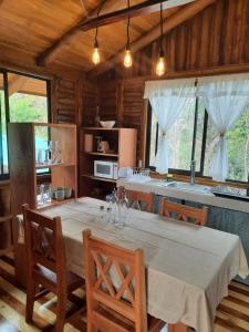 a dining room with a table and a kitchen at Eco-Turismo Guayacanes in Sámara