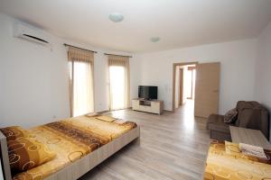 a bedroom with a bed and a couch and a television at Apartments Md Lux in Sutomore