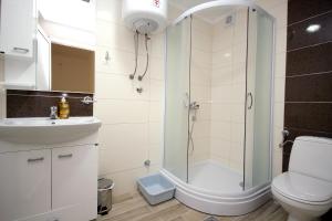 a bathroom with a shower and a toilet and a sink at Apartments Md Lux in Sutomore +13 photos