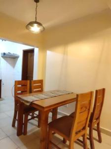mesa de comedor con 4 sillas, mesa y luz en 3Bedroom Greatwall Gardens Mombasa Rd NBO, en MakandaraHousing Estate