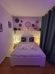 una camera da letto viola con letto e lenzuola viola di Appartement centre ville chic et cozy a Vendôme