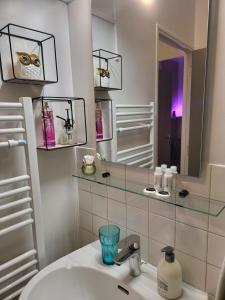 un bagno con lavandino e specchio di Appartement centre ville chic et cozy a Vendôme Altre 22 foto