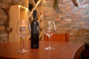 - une bouteille de vin et 2 verres à vin sur une table dans l'établissement Glamping Happiness with Sauna and Natural Pool, à Ribnica