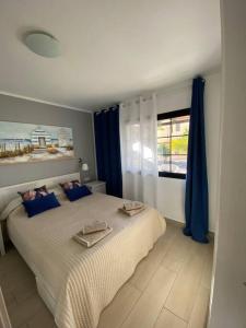 - une chambre avec un lit doté de rideaux bleus et d'une fenêtre dans l'établissement Fuerte Holiday M&M Apartaments 2, à Costa Calma