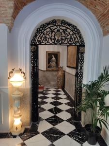 une arche avec un sol en damier noir et blanc dans l'établissement Hotel Iberia Plaza Mayor, à Cáceres