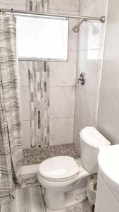 a white bathroom with a toilet and a shower at Ultra Glam Apartment 6 Miles From Hard Rock Stadium and Casino in Hollywood +20 photos