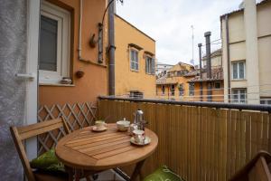 a wooden table on a balcony with two cups of coffee at Trevi Rome Central House in Rome