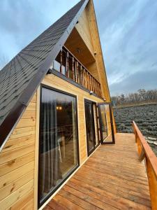 a cabin with a roof on a wooden deck at Pensiunea La Iepurasi in Lunga