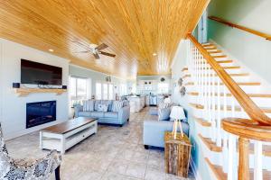 a living room with a couch and a staircase at Surf N' Turf in Dauphin Island