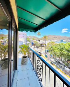 einen Balkon mit Blick auf den Strand und die Palmen in der Unterkunft Hotel La Estación in San Juan del Sur