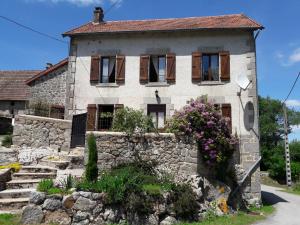 a stone house with windows and a stone wall at La maison du Mas Rando in Saint-Georges-Nigremont