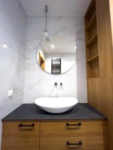 un baño con lavabo y espejo en Mint Apartments Premium Gdynia, en Gdynia 23 fotos más