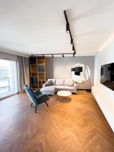 una sala de estar con un sofá y una silla en Mint Apartments Premium Gdynia, en Gdynia