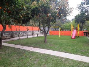 a green park bench in a grassy area next to a tree at Metro Vilar Suites & Villas in Vilar do Pinheiro