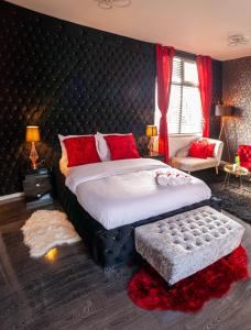 a bedroom with a large bed with red pillows at Opulent 1 Bedroom Cosy Suite in Birmingham