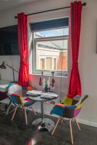 Opulent 1 Bedroom Cosy Suite في برمنغهام: غرفة طعام مع طاولة وكراسي ونافذة