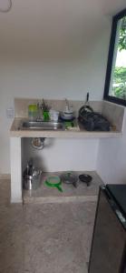 a kitchen with a counter with pots and pans at Cabañas El Olimpo in Necoclí