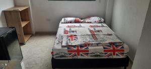a bed with a blanket with british flags on it at Cabañas El Olimpo in Necoclí