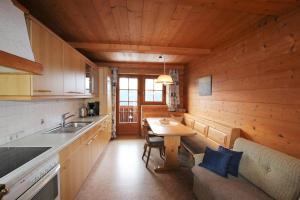 eine Küche mit einem Tisch in einer Holzhütte in der Unterkunft Wimmers Hundsegghof WILD001 in Niederau