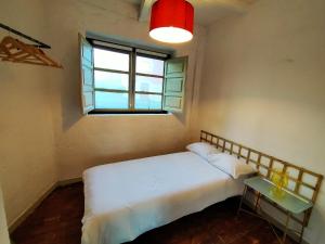 1 dormitorio con cama blanca y ventana en Loft Borines, en Borines