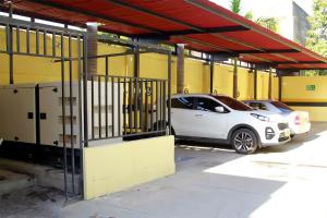 dos autos estacionados en un estacionamiento al lado de un edificio en HOTEL IMPERIAL en Maicao