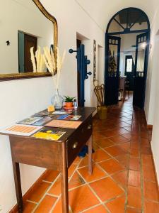 a room with a wooden table and a mirror at Às Portas da Vila in Monsaraz