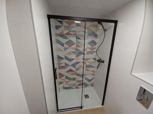 une douche avec une porte vitrée dans une salle de bain dans l'établissement CARTAGENAFLATS, Apartamentos Anfiteatro Romano 4A, à Carthagène