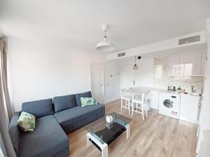 un salon avec un canapé bleu et une cuisine dans l'établissement CARTAGENAFLATS, Apartamentos Anfiteatro Romano 4A, à Carthagène 11 autres photos