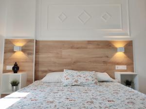 une chambre avec un lit avec une tête de lit en bois dans l'établissement CARTAGENAFLATS, Apartamentos Anfiteatro Romano 4A, à Carthagène