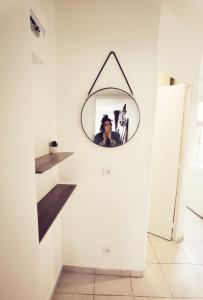 une femme prenant une photo dans un miroir sur un mur dans l'établissement Studio, TopdestinationBretagne, à Montoir-de-Bretagne
