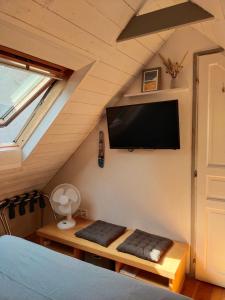 a room with a bed and a tv on the wall at Chambrecosy salle de bain privée in Quimper