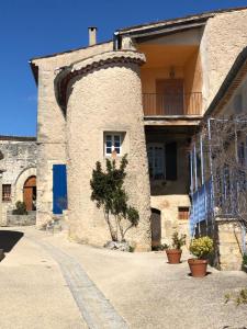 a building with a tower on the side of it at MAISON DE VILLAGE AUREL in Aurel