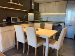 a kitchen with a wooden table and white chairs at Sliver city next to paradise mall and metro in Sofia