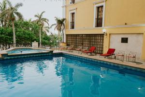 ein Schwimmbad mit Stühlen und ein Gebäude in der Unterkunft Gran Hotel Diligencias in Veracruz