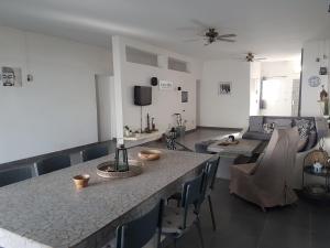 a kitchen and living room with a table and chairs at Villa JAJA Piscine-Climatisation in Poponguine