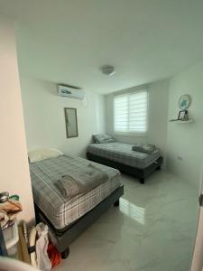 a bedroom with two beds and a window at Salinas villa in La Libertad