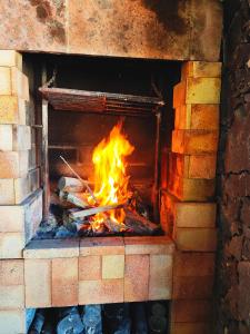 Un horno de ladrillo con fuego. en Casa con puesta de sol y montañas., en Cubaba