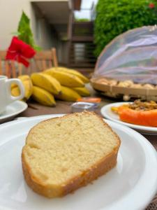 a piece of bread on a white plate on a table at Pousada Maresia in Fernando de Noronha