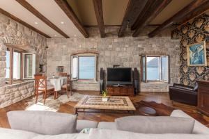 a living room with a stone wall at Kazerma Apartment in Perast