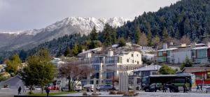 a town in front of a mountain with snow covered mountains at The Waterfront in Queenstown