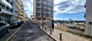 a city street with cars parked next to a tall building at Blue Home Monte Gordo in Monte Gordo