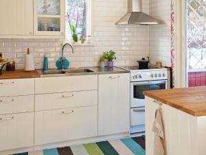een keuken met witte kasten en een wastafel bij Holiday home ORNÖ in Ornö