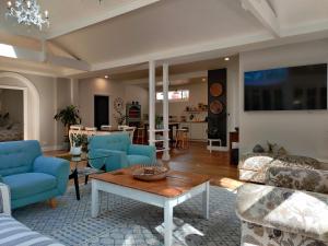 uma sala de estar com cadeiras azuis e uma mesa em WinterGreen Manor at Maleny em Maleny